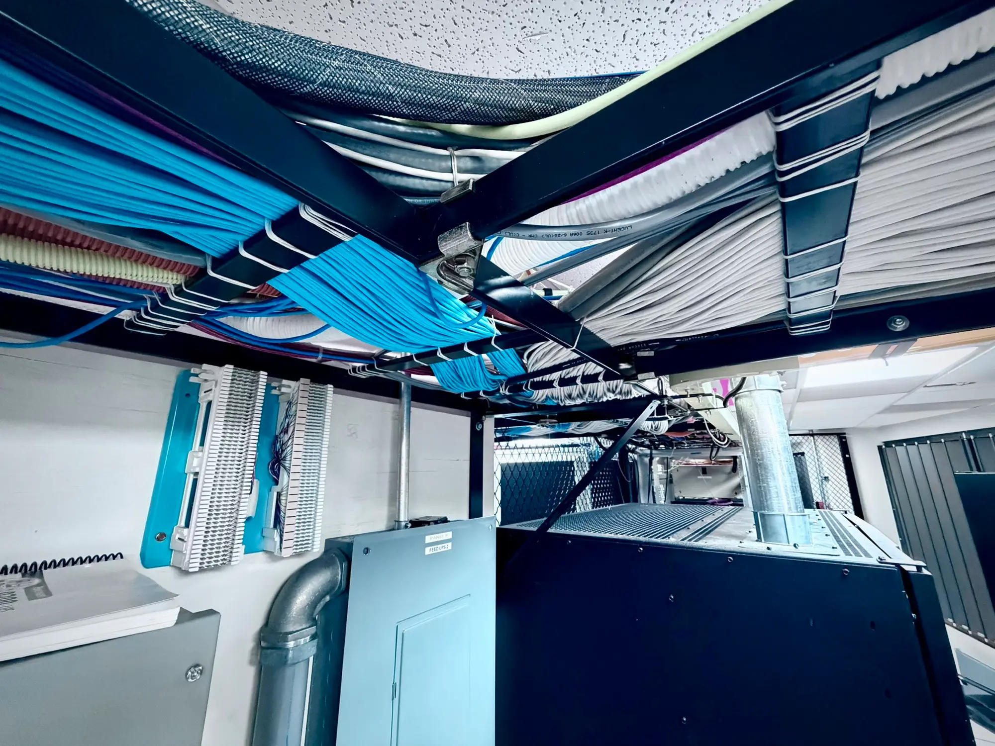 Overhead fiber trays running between cabinet rows